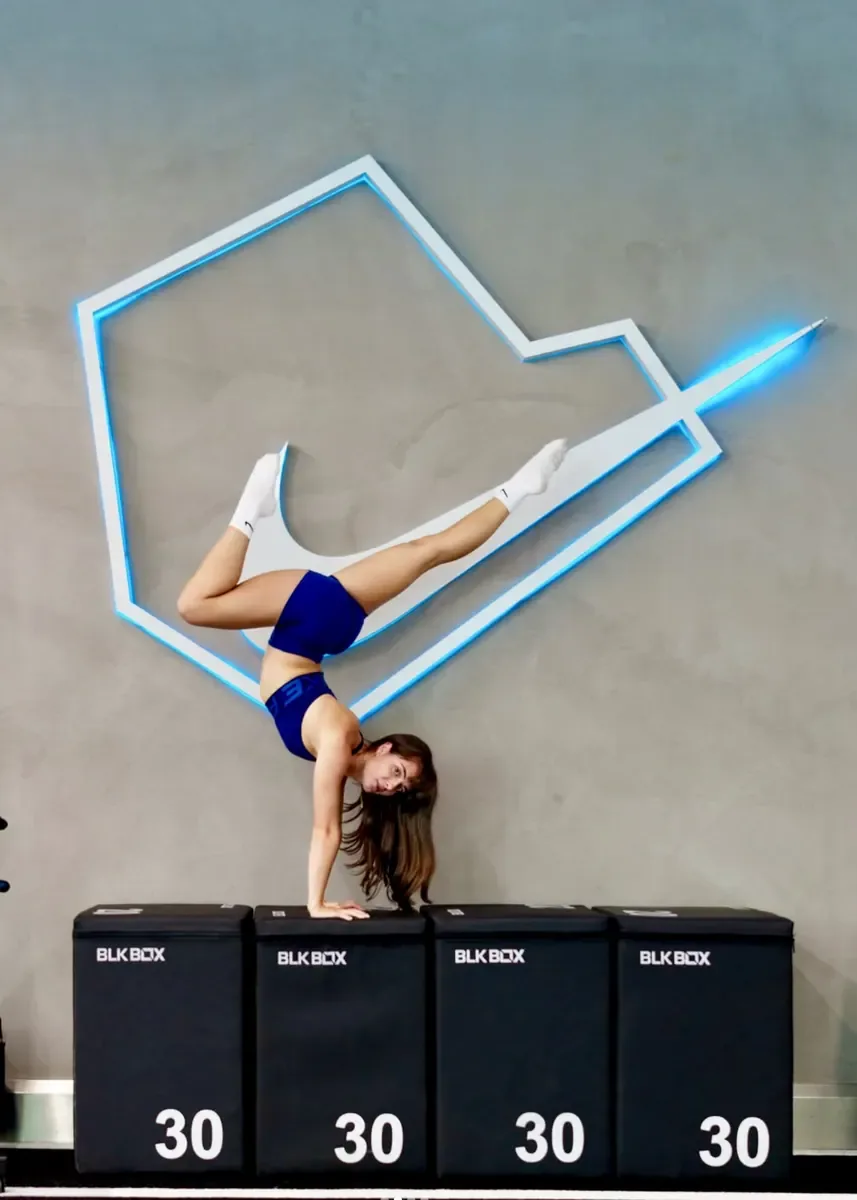 Anna Maria performing a handstand beneath the Nike Training logo