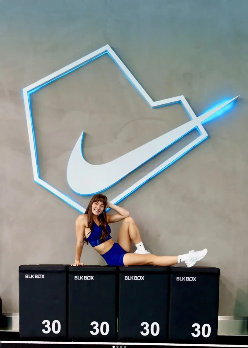 Anna Maria seated beneath the Nike Training logo